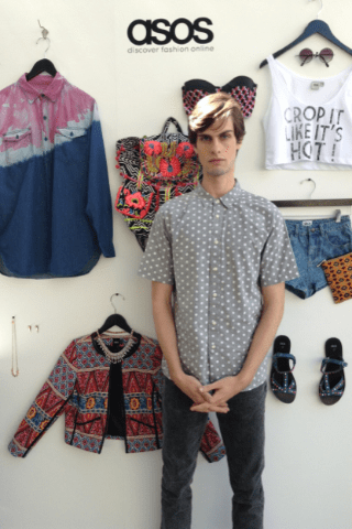 Me on my first day on the job in a gray polkadot chambray button up short with gray jeans, all by ASOS, in front of one of its displays.